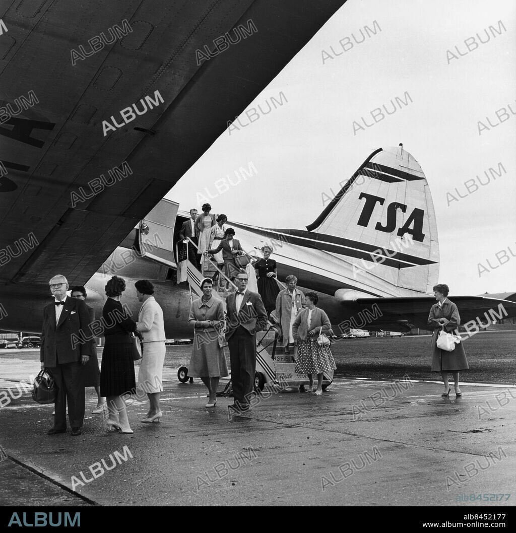 Bulltofta flygplats 1959 med passagerare som lämnar flygplanet. Transair vid denna tid Sveriges enda stora charterbolag. Malmö flygplats Bulltofta plattan uppställt flygplan 1959. Malmö företag Flyg bolag Transair. Flygplanstyper Curtiss Commuter - 56 passagerare eller 5,5 ton frakt. Åke Håkansson / Rubin / SYDSVENSKAN / IBL BILDBYRÅ.