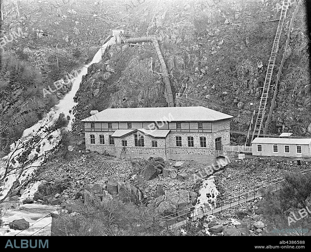 Negative - Cataract Gorge, Launceston, Tasmania, circa 1900, The Duck Reach hydro-electric generating station in the second basin of the Cataract Gorge near Launceston. There are steps up the cliff face on the right and a suspension bridge in the foreground. Flume and penstock are above the station. This was the first hydro-electricity station in the world used to provide power to a city and first operated in 1895. In 1929, the station was largely destroyed.