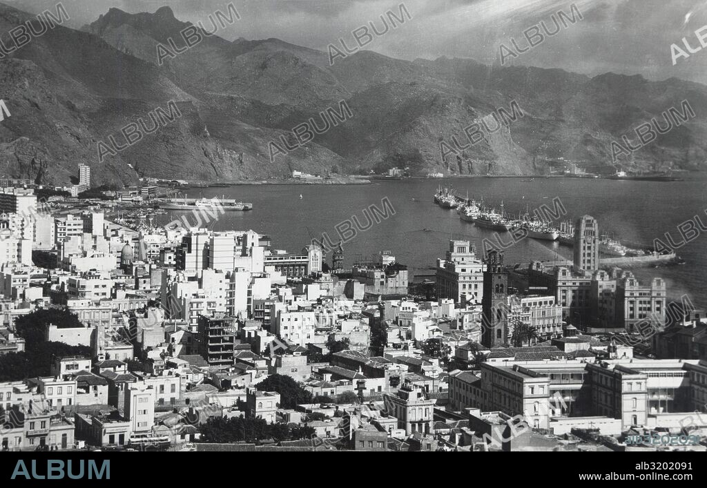 Islas Canarias. Santa Cruz de Tenerife. Vista aérea de la ciudad y el puerto con el macizo de Anaga al fondo. Años 1950.