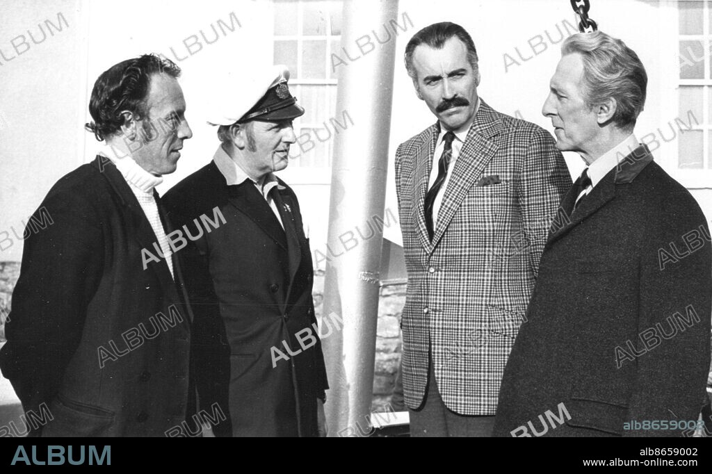 Horror kings Christopher Lee and Peter Cushing chat to two ferrymen at Dartmouth, Devon during the filming of Nothing But the Night in 1971.