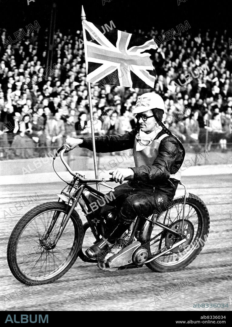 Moore Leads Australia To Speedway Victory -- England's Captain, Norman Parker, rides round flourishing a union jack before the test began. He rode with his left leg in Irons because of a previous injury.
Ronnie Moore, Wimbledon's 19-year-old Australian Speedway star, the youngest rider to captain a test team, led his country to victory over England by 56 points to 52 in the first test at Wmbledon last night.
This daring young man who defied the wall of death when he was only 12, also defied the best opposition England could offer, to score his first test maximum and to pocket nearly £100 in prize money. June 10, 1952. (Photo by Paul Popper, Paul Popper Ltd.).