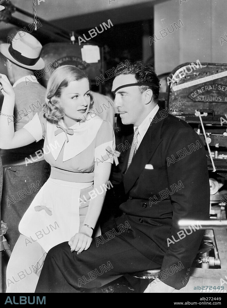 JOAN BENNETT and RAOUL WALSH in BIG BROWN EYES, 1936, directed by RAOUL WALSH. Copyright PARAMOUNT PICTURES.