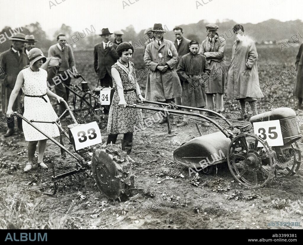Berlin, Germany:  c. 1928 Two young girls demonstrate the ease with which these new gasoline powered hand tractors for the small farm be may be operated.