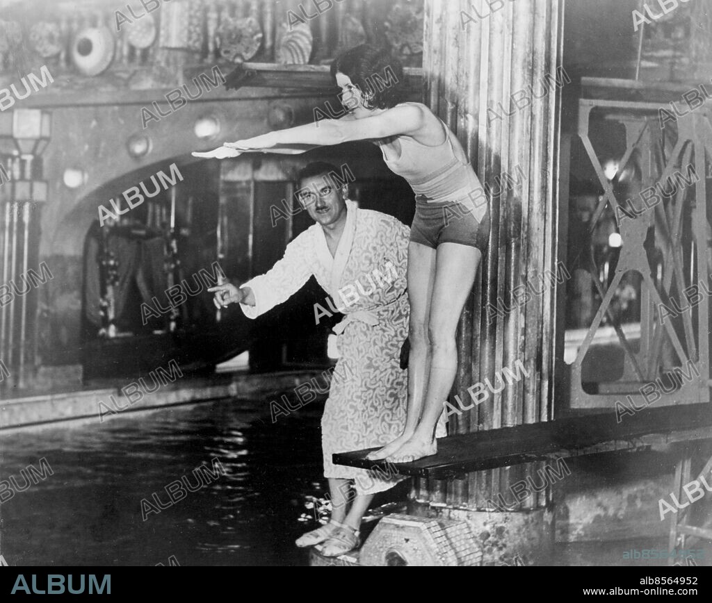 Orig. bildtext... TO DANCE AMONG LIONS. Paris actresses keep slim and supple by swimming. Here is a Parisian star, Mdlle Mona Paiva (known to Cochran audiences of a few years ago) taking her morning lesson at the sumptious Paris Lido from the well known swimmer Georges Pouilley. For a charitable work Mdlle. Paiva, dressed in an animal skin, braved the dancers of the lions den in Paris and danced a remarkable dance in aid of the children. Her worst moment was when she entered the cage. Anm. Trampolin Peka Baddräkter Badrockar CD426 persons: GEORGES POUILLEY;MONA PAIVA sites: PARIS;FRANKRIKE.