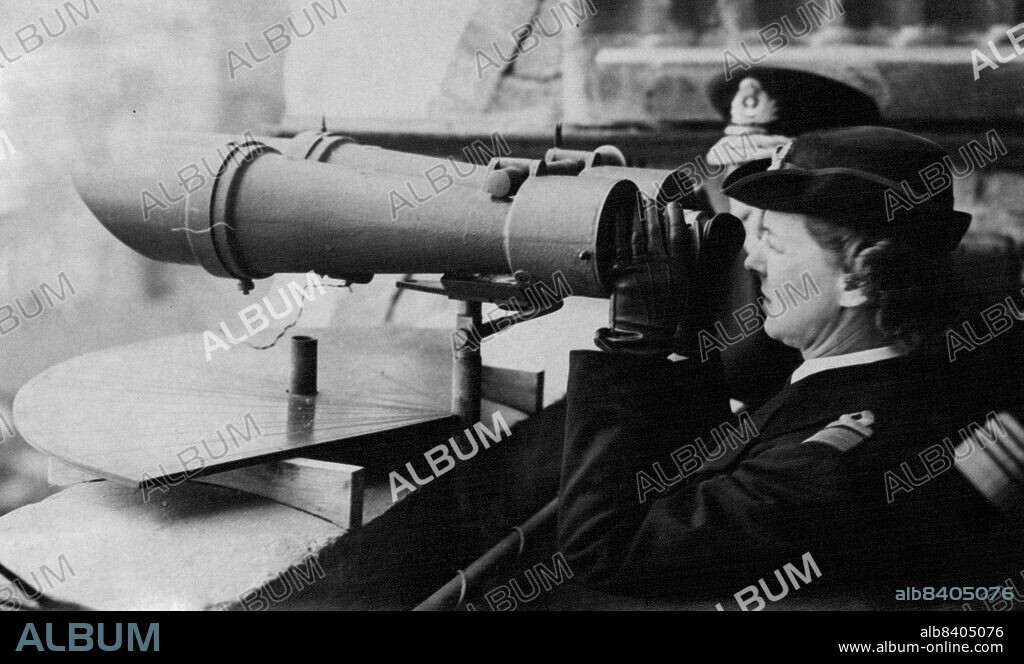 Duchess of Kent Visits The Wrns In The Dover Command -- The Duchess of Kent on the Admiral's balcony in Dover Castle Scans the French coast through binoculars that were taken from the Italian battleship "Littorio"."Dover would be the first battle honour if the WRNS carried colours" the Duchess of Kent who is the Commandant of the Wrens told them yesterday after inspecting their establishments in the Dover Command. One of the buildings she visited was the workshop of the Torpedo Wrans - The pluckiast girls in Britain - under shell and bomb fire they continued on their job day after day, checking, overhauling and cleaning torpedocs for light coastal craft which were keeping the Straits open. October 12, 1944.