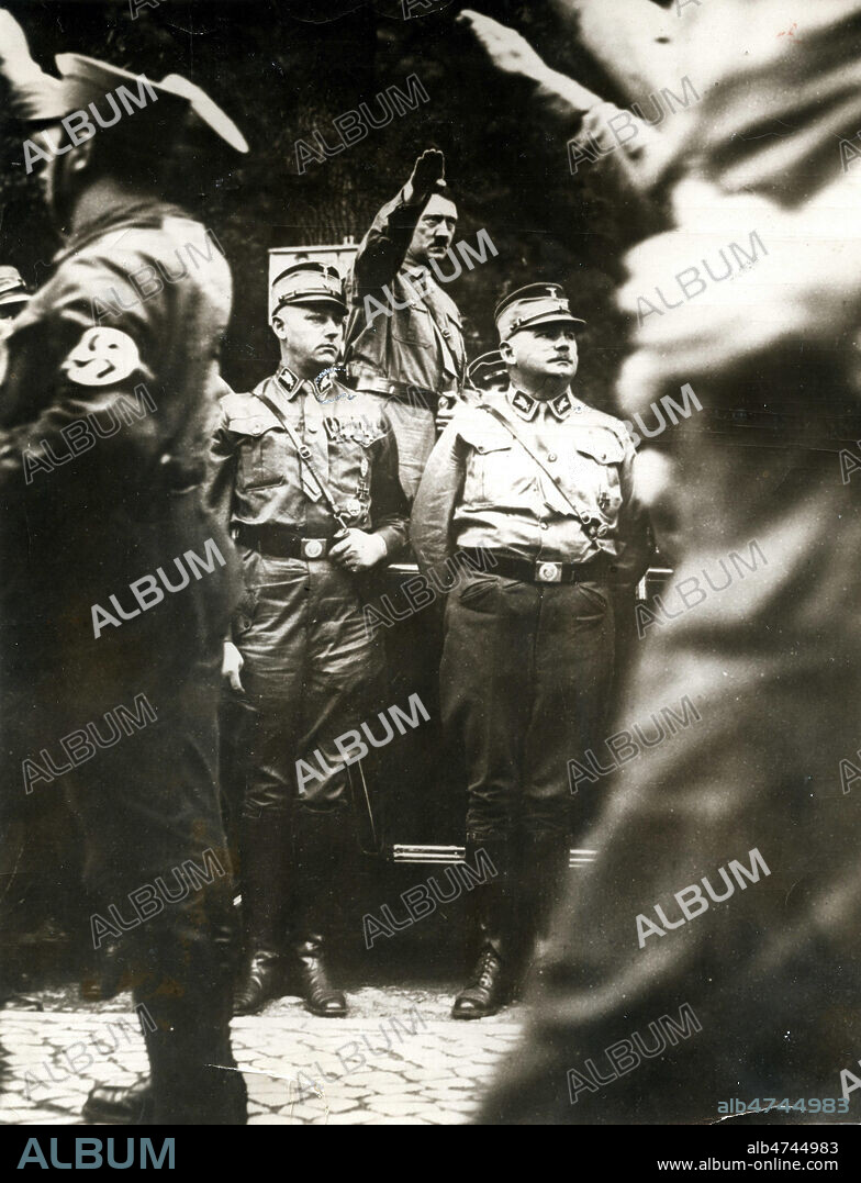 Adolf HITLER (1889-1945) assistant a un defile militaire des S.A. Sturmabteilung, en 1933. Devant lui se trouve Ernst RÖHM le chef des SA. Collection privee. Credit NBL/KHARBINE TAPABOR.