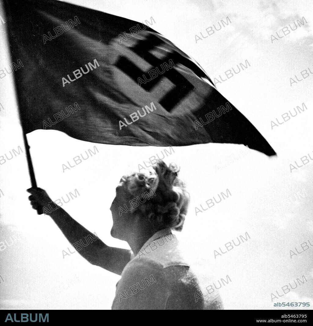 Woman waving Nazi flag circa late 1930s or early 1940s.