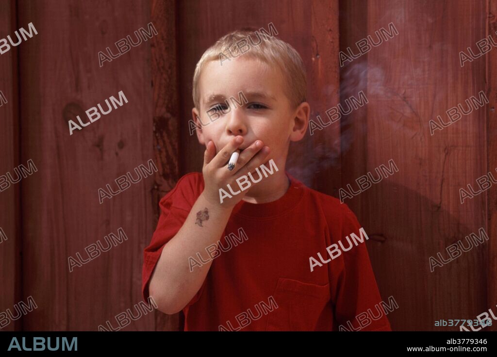 A four-year-old boy smokes a cigarette.