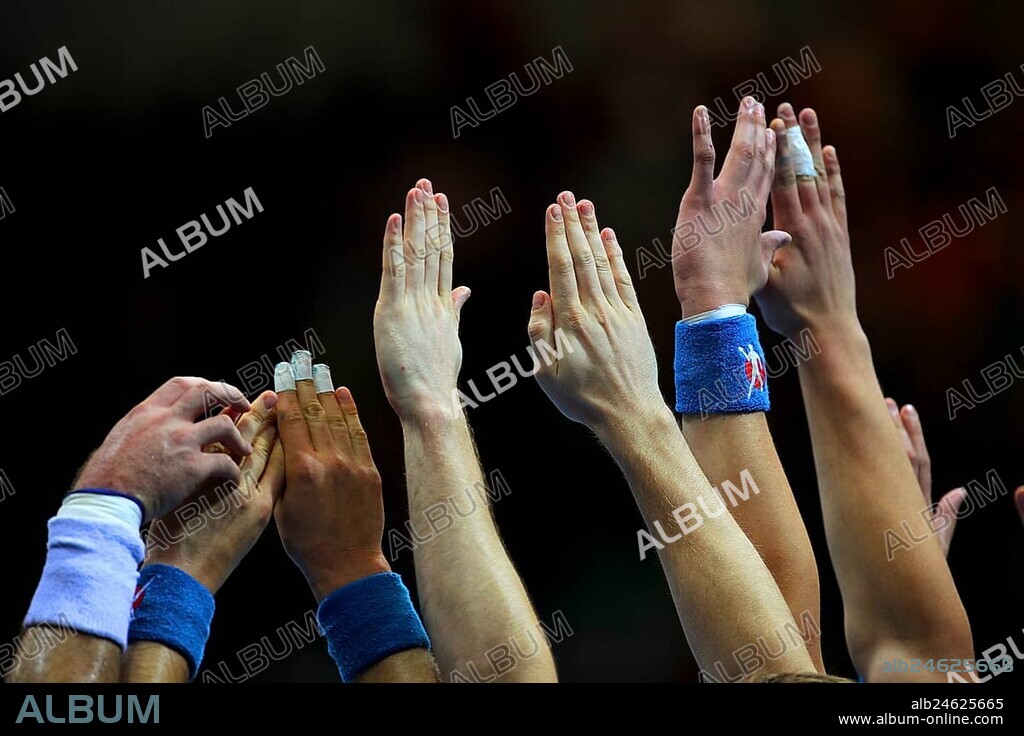 Handball players stretch their hands up to fend off a free-kick