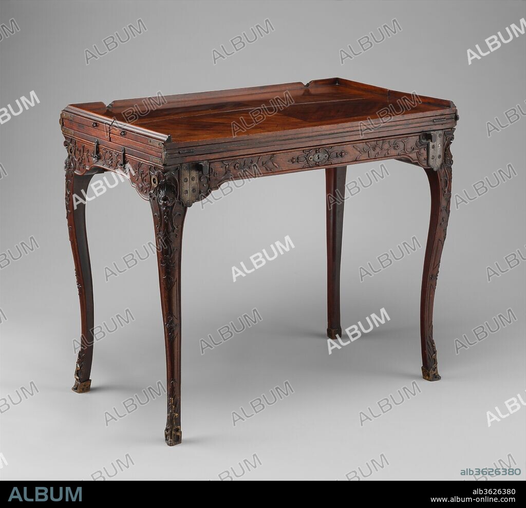 Traveling table (table de voyage or table pliante). Culture: French. Dimensions: 28 1/2 x 33 1/4 x 19 3/4 in. (72.4 x 84.5 x 50.2cm); Depth (when fully extended): 58 1/4 in. (148cm). Date: ca. 1700-1720.
The Château de Saint-Cloud, near Paris, belonged to the ducs d'Orléans until 1785. In the estate inventory of the furnishings in the rooms of Duchesse Élisabeth Charlotte (1652-1722), called Madame, sister-in-law of Louis XIV, there is mentioned a carved writing desk made of walnut on pieds de biche (doe's feet). The French term could be taken literally, because zoomorphic feet for furniture was a very fashionable conceit in the seventeenth century. But the term could also refer to the slim, stylized S-curved legs of late Louis XIV and early Régence style that suggest the sweetly elegant stance of the deer. This leg shape, seen also on the Museum's table, appeared about 1700 at the latest-certainly not in the Rococo period, as has long been maintained.[1]
This refined and ingeniously constructed table[2] is a very rare example of a type of multifunctional furniture that was specifically invented for rough and space-limited journeying via coach. Before the advent of the automobile, a traveler could not count on finding the comforts of home at a place where he found himself benighted or stranded by unforeseen events, such as a broken axle-a misfortune that occurred often on unpaved roads. 
The fashionable pieds de biche of the Museum's table are hinged to the top and can be folded and locked underneath, making the piece easy to pack away.[3]  When standing, it could be used for serving food and beverages, and the raised molding along three sides would prevent valuable and fragile items from sliding off the beautifully grained surface. The fine, flat-carved decoration on the apron conceals a drawer for storing utensils. The tabletop can be extended by unfolding several leaves on either side. These are supported by steel pullout bars. There is a surface covered with leather for writing and another covered with felt for playing cards or dicing. Fully extended, the table could accommodate a company of at least six diners. The legs are decorated with a highly sophisticated design of low-relief carving incorporating floral sprays, small fruits, shell motifs, and interlaced strapwork.
The only known walnut table with similar folding mechanisms is very close to this table in its measurements. It once belonged to the princes de Condé and is now in the Musée des Arts Décoratifs in Paris.[4]
[Wolfram Koeppe 2006]
Footnotes:
[1] Wolfram Koeppe. "Möbel und Schaustücke." In Liselotte von der Pfalz: Madame am Hofe des Sonnenkönigs, ed. Sigrun Paas, pp. 179-88. Exh. cat., Heidelberger Schloss. Heidelberg, 1996, pp. 184-85, fig. 5.
[2] Katharine Baetjer et al. "The Jack and Belle Linsky Collection in the The Metropolitan Museum of Art: Addenda to the Catalogue." Metropolitan Museum Journal 21 (1986), pp. 165-66, no. A.5 (entry by James Parker)
[3] Yet another name for this type of table is table pliante, or folding table; Henry Havard. Dictionnaire de l'ameublement et de la décoration depuis le XVIIIe siècle jusqu'à nos jours. 4 vols. Paris, 1887-90, vol. 4, col. 1208.
[4] Yvonne Brunhammer, ed. Cent chefs-d'oeuvre du Musée des Arts Décoratifs. Exh. cat., Pavillon de Marsan, Palais du Louvre. Paris, 1964, p. 64; Pierre Kjellberg. Le mobilier français. Vol. I, Du Moyen Âge à Louis XV. Vol. 2, De la transition Louis XV-XVI à 1925. Paris, 1978-80, vol. 1, fig. 117; and Pierre Verlet. Les meubles français du XVIIIe siècle. 2nd ed. Paris, 1982, p. 132, fig. 29.