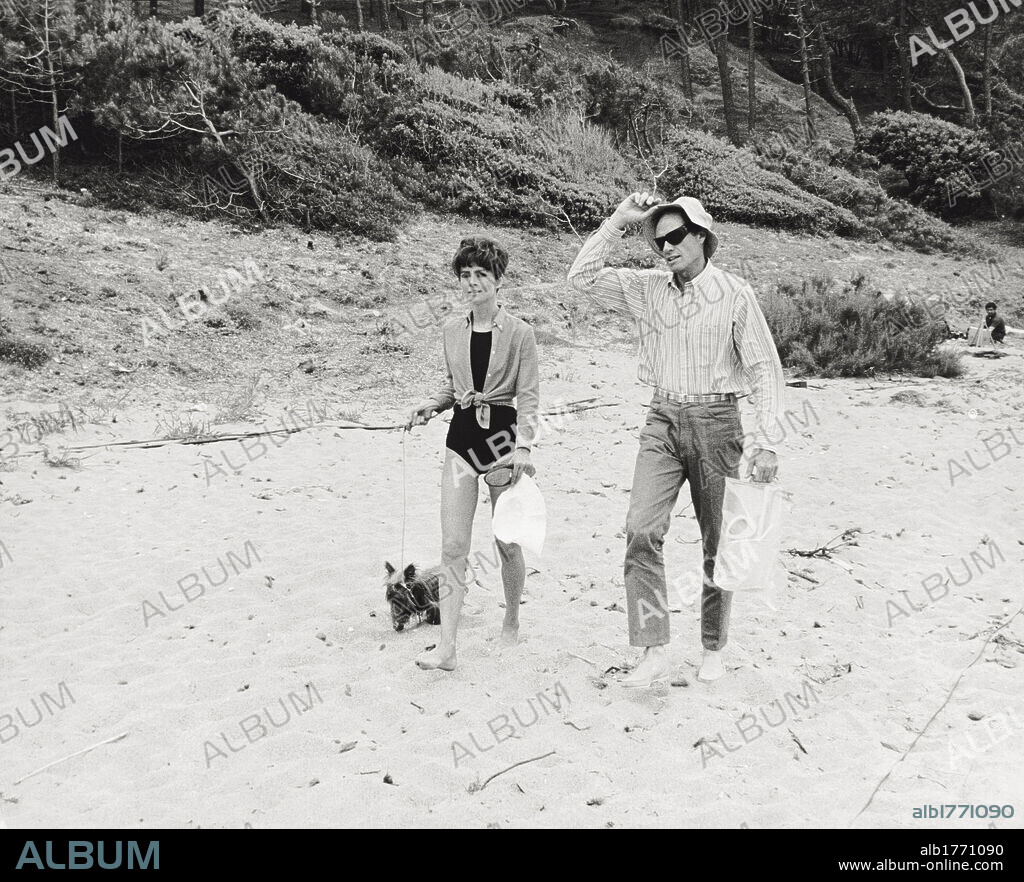 Audrey Hepburn and Mel Ferrer. The British actress Audrey Hepburn and her husband and American director Mel Ferrer walking on the sand. August 1966.