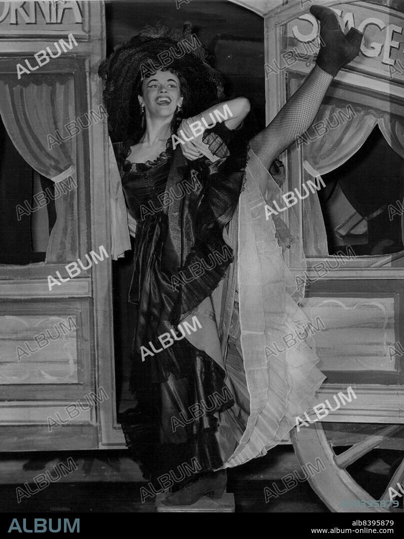 Dizzy girl is portrayed by Clemence Bettany, 18m of Adelaide, who has been learning ballet for nine years. She is wearing a coat of purple velvet, a skirt of purple Satin and black net, cyclamin and lilac petticoats, Ostrich feathers in her hat and red boots. June 25, 1955.