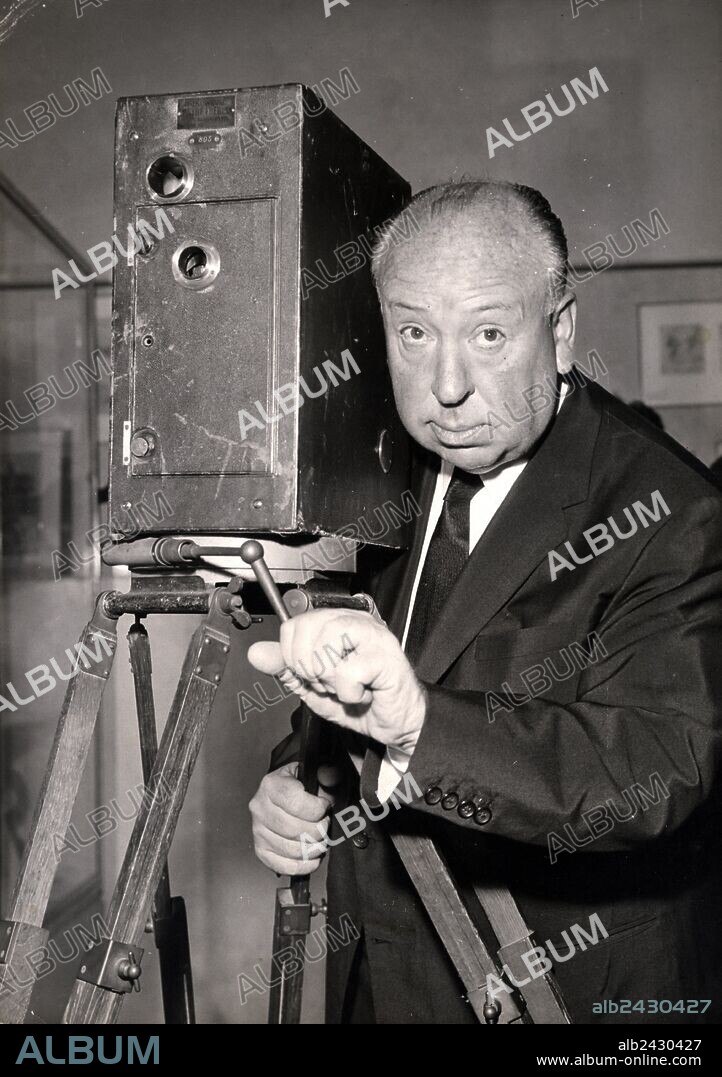 ALFRED HITCHCOCK. May 28, 1960 - Paris, France - Film director ALFRED HITCHCOCK, in Paris visiting a museum for cinema archives, explains Patee Brothers first cinema camera. 28/05/1960