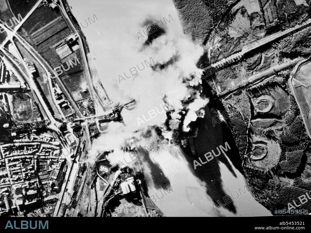 U.S Bomb Bursts Cover Bridge ***** ItalyClouds of smoke cover the Piacenza railroad bridge after medium bombers of the 12th U.S Army air force had struck this vital target in northern Italy. Part of the Mediterranean Allied air force, the 12th is lending tactical support to Allied ground force fighting in the rough terrain before the broad Po Valley. Now supporting allied land force pushing the Germans back toward the ***** Alps, its pilots are also veterans of the campaigns in North Africa and Sicily. December 13, 1944. (Photo by U.S. Office of War Information Picture).