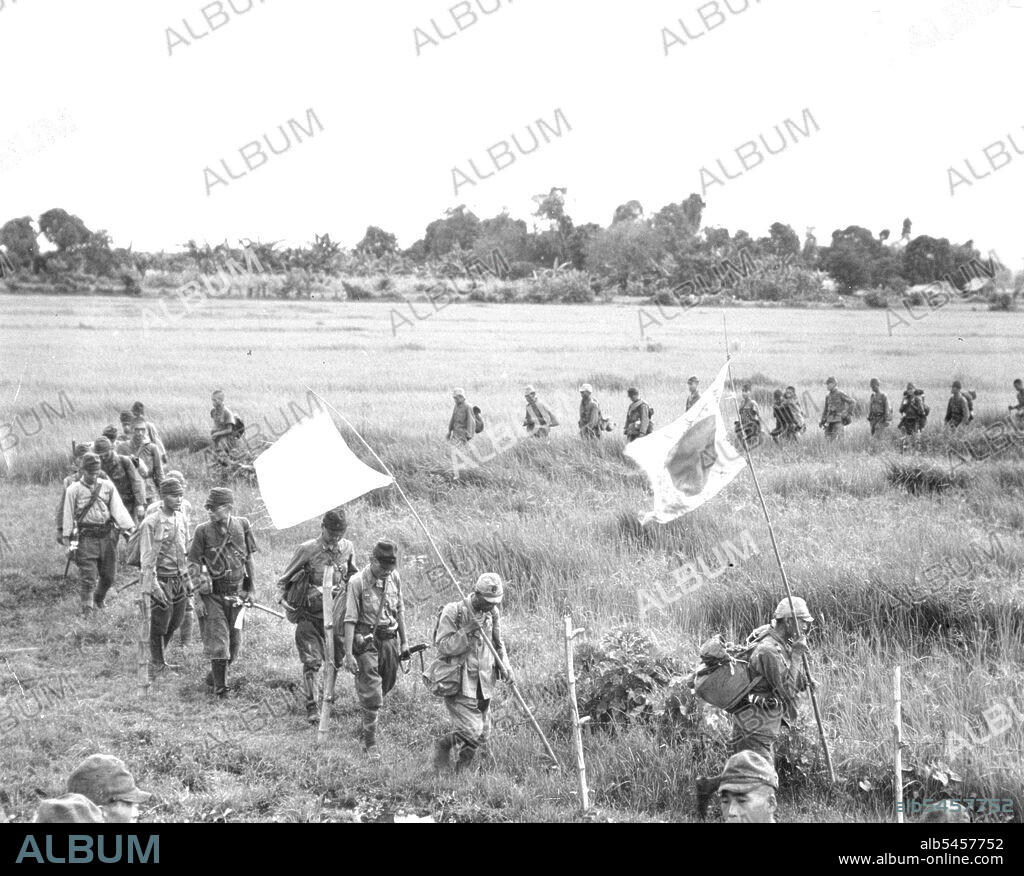 Japs Surrender At Bataan - A serpentine column of surrendering Japanese soldiers cross a green rice paddy as they approach waiting 38th Div. troops. Fifty officers and 400 men, all that remained of more than 6,000 enemy troops, surrendered at Orion and Bagac, Bataan. They are shown moving along the same trail over which Americans made the infamous "death march" in 1942. This enemy force, under Col. Nagayoshi was completely defeated in battle by veteran 38th Div. troops in their reconquest of historic Bataan peninsuls. April 9, 1945. (Photo by U.S. Army Photo).