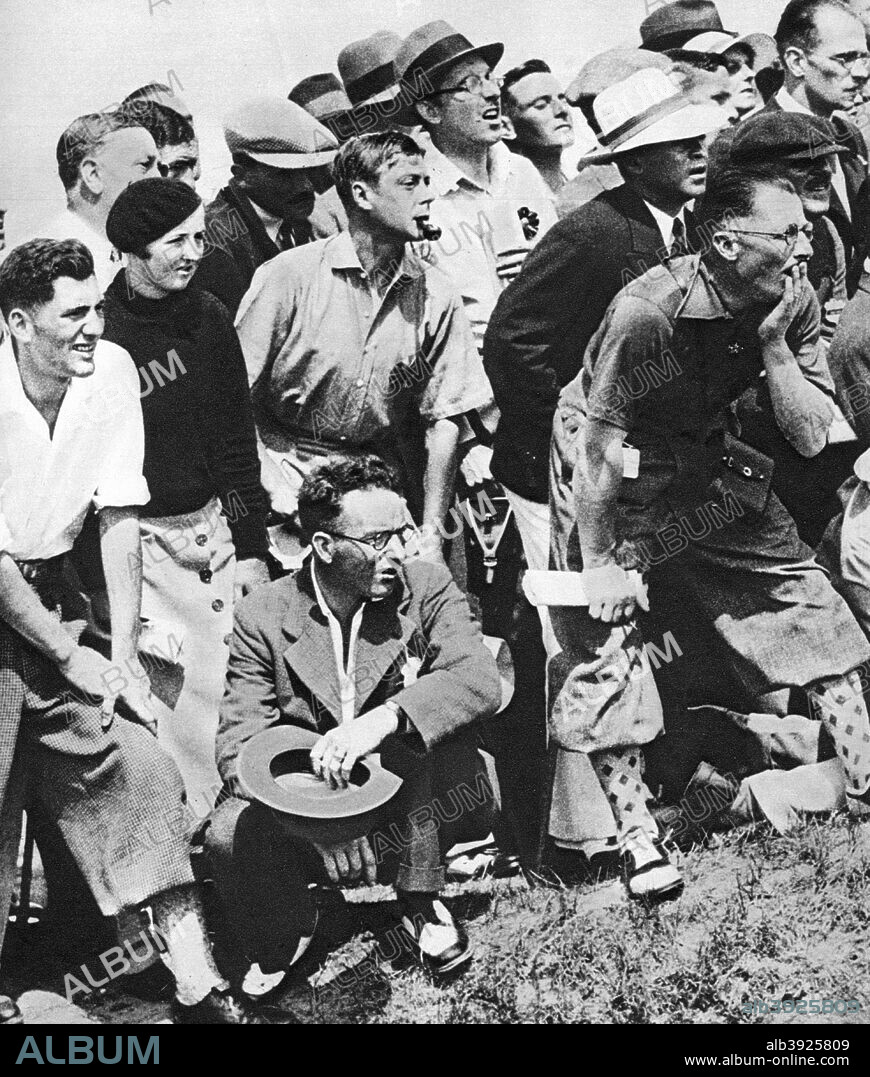 The Prince of Wales smokes a pipe while watching play in the Open Golf Championship, St Andrews, c1930s. The future King Edward VIII enjoys a sporting event. Illustration from George V and Edward VIII, A Royal Souvenir, by FGH Salusbury, a souvenir book published as Edward VIII was crowned following the death of his father, George V, (Daily Express Publication, London, 1936).