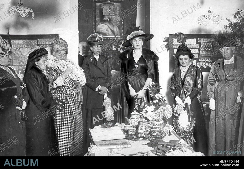 28 mayo 1917. En el taller del Encaje. Ss. Mm. la Reina doña Victoria (1) y doña María Cristina (2) y S. A. R. la Infanta doña Isabel (3), con las Condesas de pardo Bazán (4) y san Rafael (5), en el acto inaugural de la exposición de Encajes, Verificado ayer.
