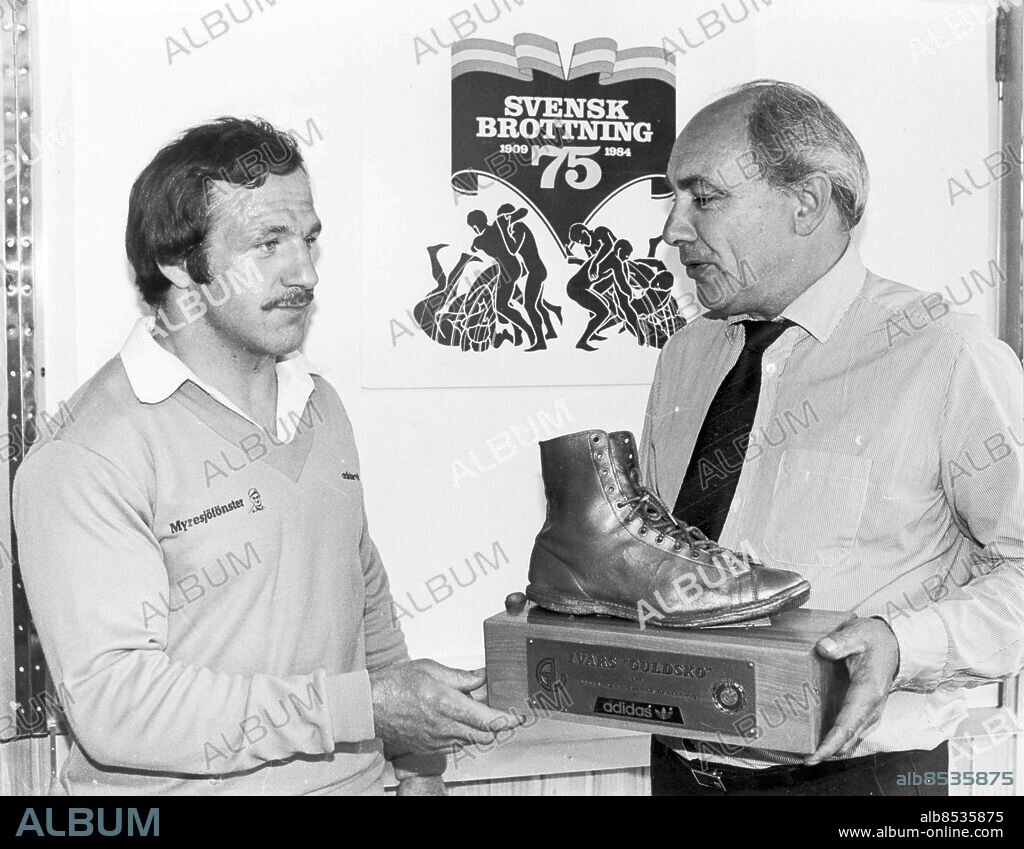 Göteborg 1984-06-04. Brottaren Lennart Prosten Lundell får Ivars guldsko av Lars Stenfeldt, Svenskla Sportjournalisternas förbund - Ivars Guldsko är en utmärkelse till årets bäste svenske brottare. Priset utdelas sedan 1981 i samarbete mellan Svenska Brottningsförbundet och Adidas. Vandringspriset är en förgylld brottarsko, som pristagaren vinner en inteckning i, samt tilldelas en miniatyr av. Brottarskon, som är den som Ivar Johansson använde då han blev guldmedaljör i brottning vid OS i Berlin 1936, har donerats av Ivar Johanssons maka Ingrid *** Local Caption *** GP Foto: Bengt Magnuzon. KAMERAREPORTAGE.