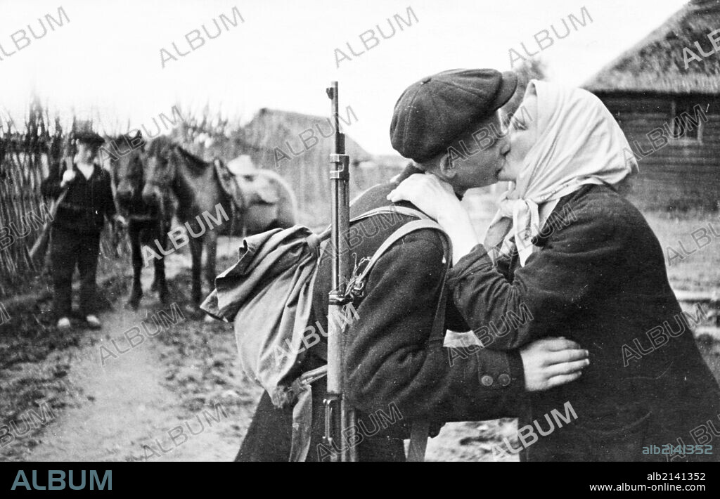World war 2, a russian partisan in the leningrad region kissing his mother good-bye before leaving with his detachment.