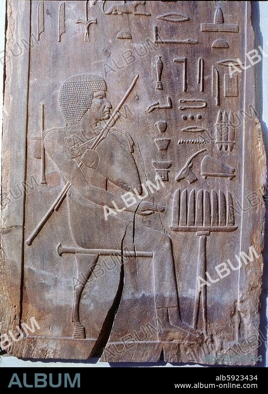 One of six panels from the mastaba of Hesire, a high official of King Zoser who was Chief of Dentists and Physicians as well as holding other titles. He is shown seated before an offering table and he carries ink- wells in a palette, a pen case & bag over (..).