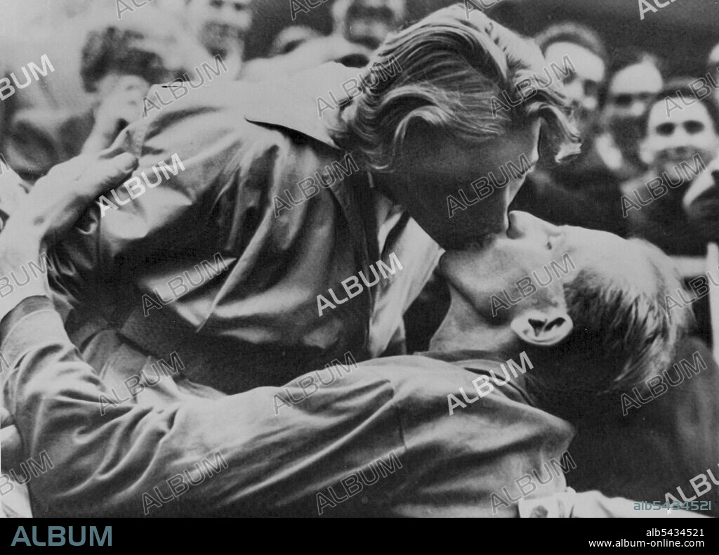 Wife Kisses Zatopek After Marathon Win -- Congratulatory kiss from his wife for Czech Army Major Emil Zatopek after he had won the marathon Olympic Games event to-day. The win marks the first time in history of the Games that an athlete has won all three of the long distance races; marathon, 10,000 and 5,000 metres. Reinaldo Corno of Argentina was second and Gustaf Jansson of Sweden third. Zatopek's wife, Dana Zatopkova, is herself an Olympic-gold medal winner, being victor of the women's javeli.