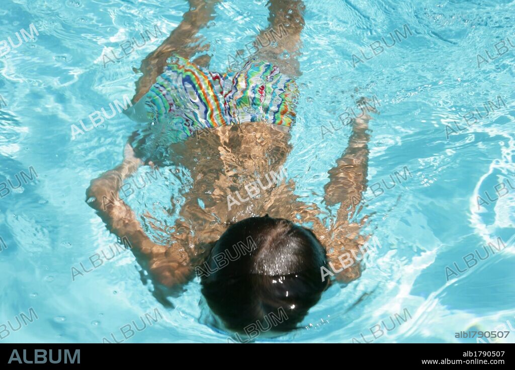 NIÑO de siete años buceando en una piscina.