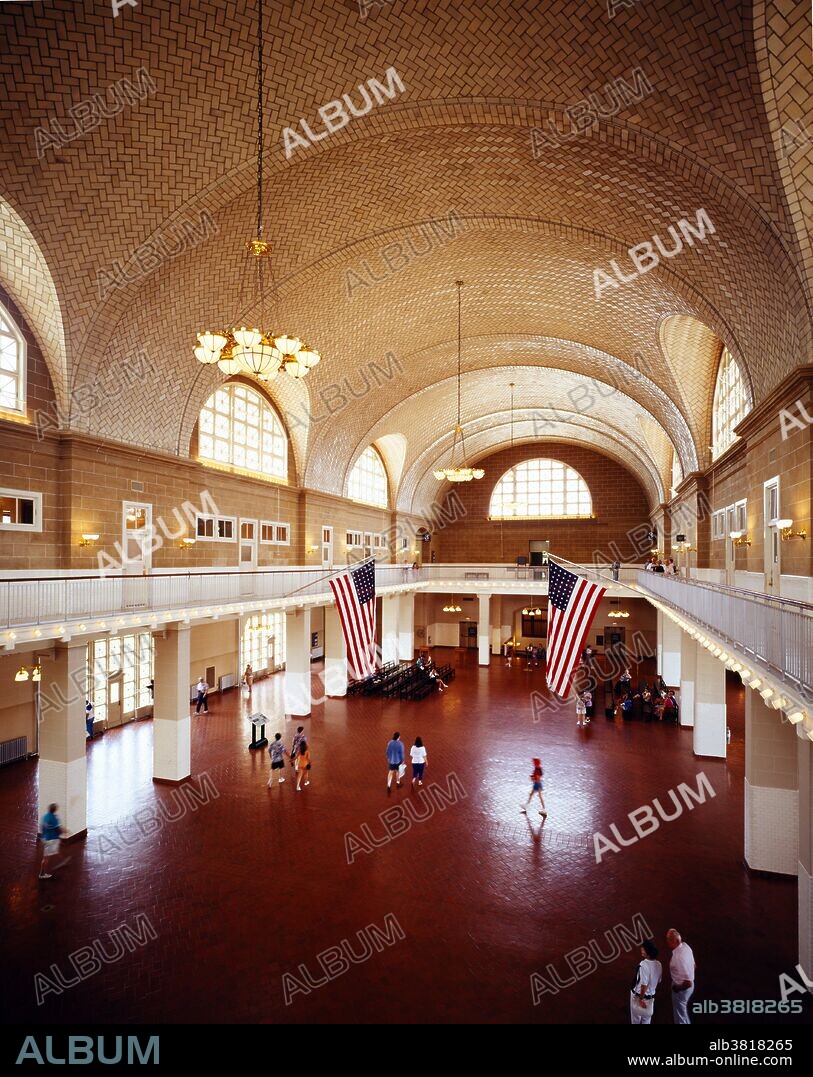 Interior view of the Great Hall(blt.1900), of the Ellis Island Immigration Museum. The building is one of New Yokrs few grand-scale brick buildings. The wonderful vaulted ceiling is the work of the Gustavinos, a family of tile makers from Spain. It waas installed in 1918. The room itself is 338 Ft. long by 168 feet wide.This was the room into which immigrants were first brought into to be examined and processed. It was restored in 1991 and is now part of the Ellis Island-Statue of Liberty National Monument. The island is located at the mouth of New York Harbor on the New Jersey side of the Hudson River. The ownership of the island is shared by the two states.