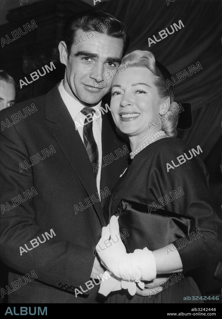 Orig. bildtext... LANA TURNER MEETS HER NEW LEADING MAN Blonde film star Lana Turner,as beautiful as ever at 37, and dark haired young man namned Sean Connery, aged 26, toasted each other in the candlelight of a west end restaurant last night. Miss Turner had arrived a few hours earlier from Los Angeles Sean Connery, who hails from Edingburgh, has been loaned to paramounth after his successful parts in hell drivers and time lock. Now he will film with Miss Turner in Another Time, Another Place. Photo shows:- Lana Turner photographed in London last night with her new leading man Sean Connery. Anm. Handskar Pärlhalsband Leende persons: SEAN CONNERY;LANA TURNER sites: LONDON;USA*;STORBRITANNIEN.