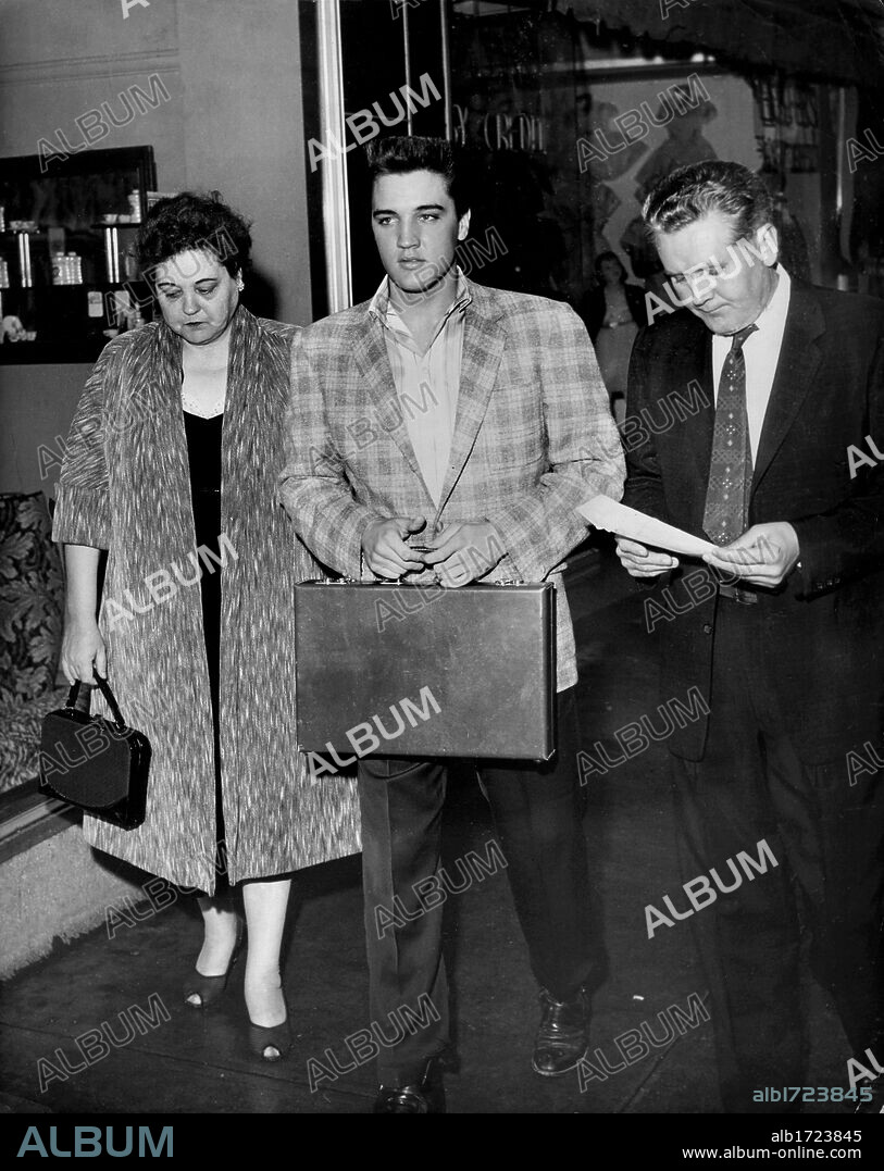 Elvis Presley, GLADYS PRESLEY et VERNON PRESLEY. Mar. 24, 1958 - Memphis, TN, U.S. - Flanked by his parents, Gladys & Vernon, Elvis Presley reported for Army duty to the Draft Board office in the M &M Building at 198 South Main about 6:30 a.m. March 24, 1958. After undergoing processing and a physical at Kennedy Veterans Hospital, he and other inductees would board a bus for Fort Chaffee, Arkansas later that afternoon. By the 28th, Elvis arrived at Fort Hood, Texas where he would undergo six months training before shipping off to Germany. His mother would die before he completed training. (Credit Image: © The Commercial Appeal/ZUMApress.com). 24/03/1958