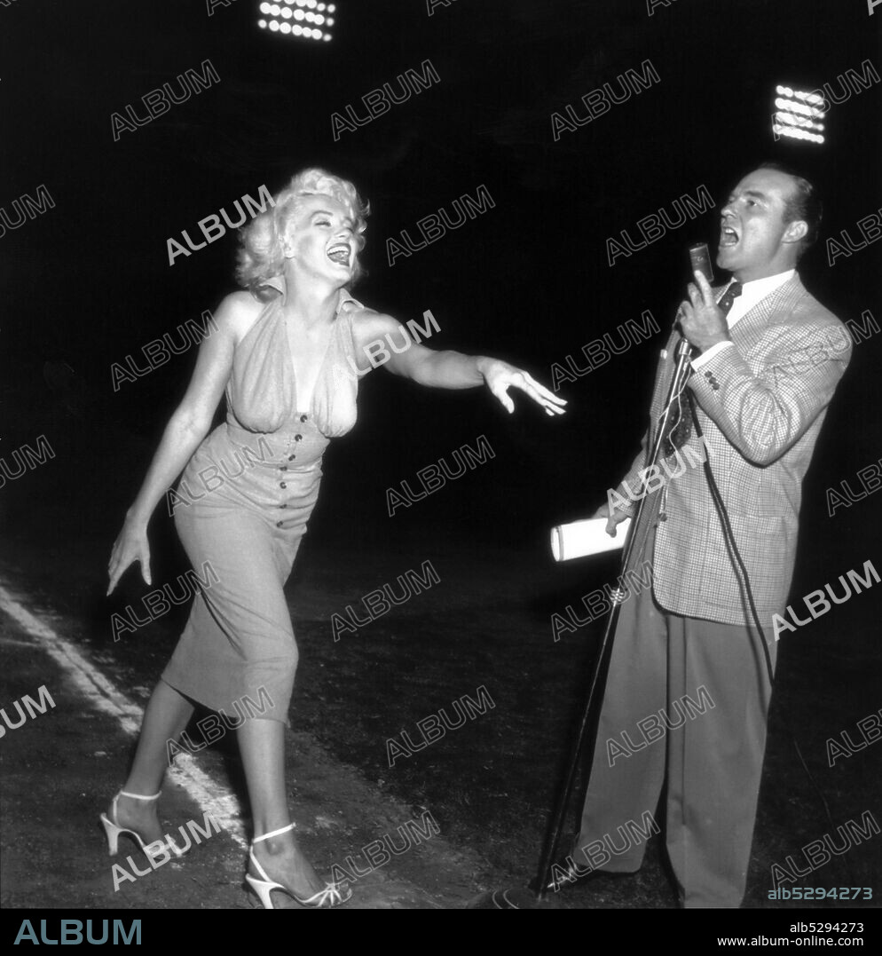 MARILYN MONROE. 1952, Hollywood, California, USA: Hollywood icon actress MARILYN MONROE takes pitch to radio presenter RALPH EDWARDS at Seal Stadium for the Hollywood Entertainers Baseball Game 1952.