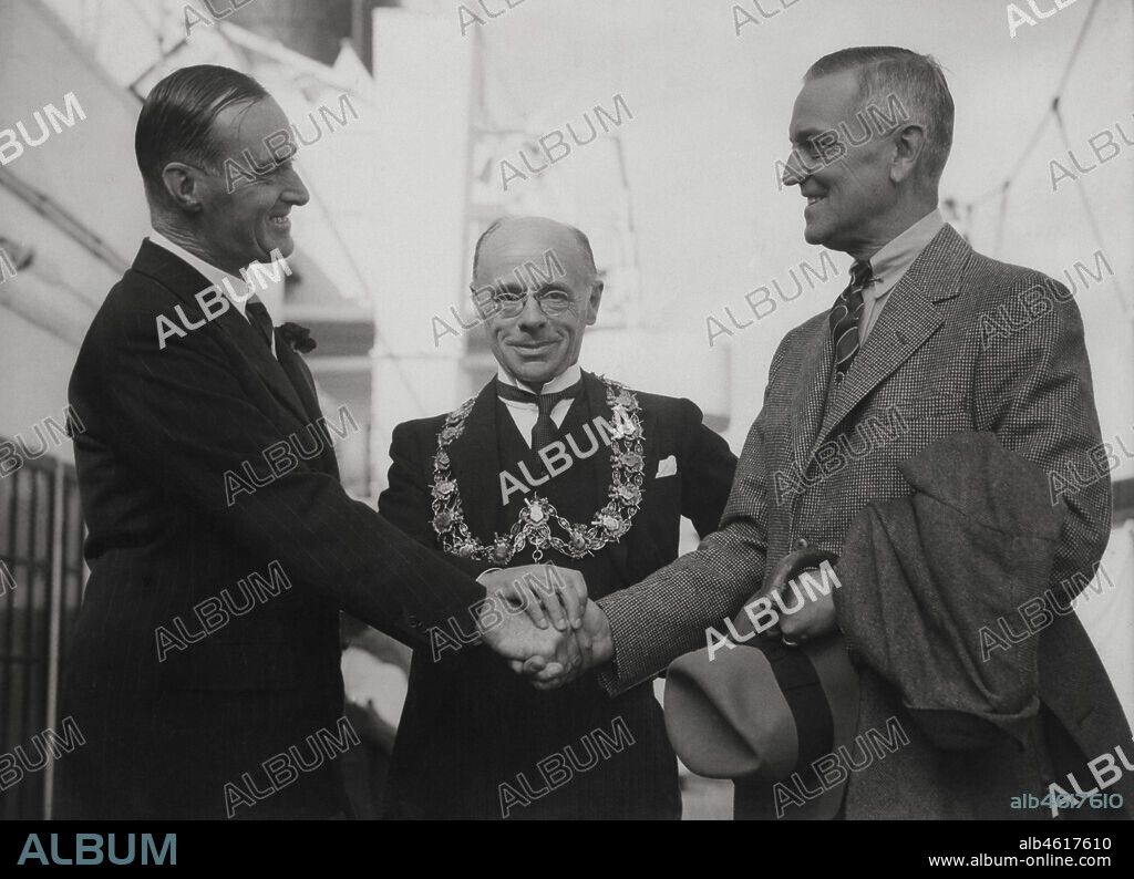 Malcolm Campbell (1885-1948), piloto automovilista británico, récord mundial de velocidad con su automóvil Pájaro Azul en las pistas de Utah, Estados Unidos, saludando al embajador norteamericano B.W. Bingham en presencia del alcalde de Southampton. Año 1935..