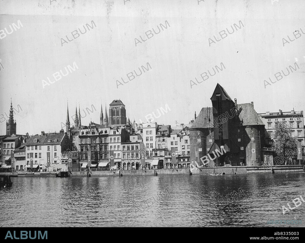 New Pictures of Danzig - Nazis Pour Into Free City.
A new picture of the inner harbour of Danzig, known as the "Long Bridge". Also in the picture are three of Danzig's landmarks. Right foreground is the 15th century Krantor gate, notable for its stone and wood construction and now adorned with the Nazi swastika. Extreme left is seen the graceful spire of the Rathaus (City hall) and in centre the solid tower of the Marienkirche, one of the city's best-known churches. 
One thousand four hundred armed Germans and lorry loads of arms and munitions are reported to have arrived in Danzig from East Prussia. Rumours of an impending coup are circulating.
More than 2,000 members of the German armed forces are now said to be in Danzig, and Polish military preparations are also reported. June 28, 1939.