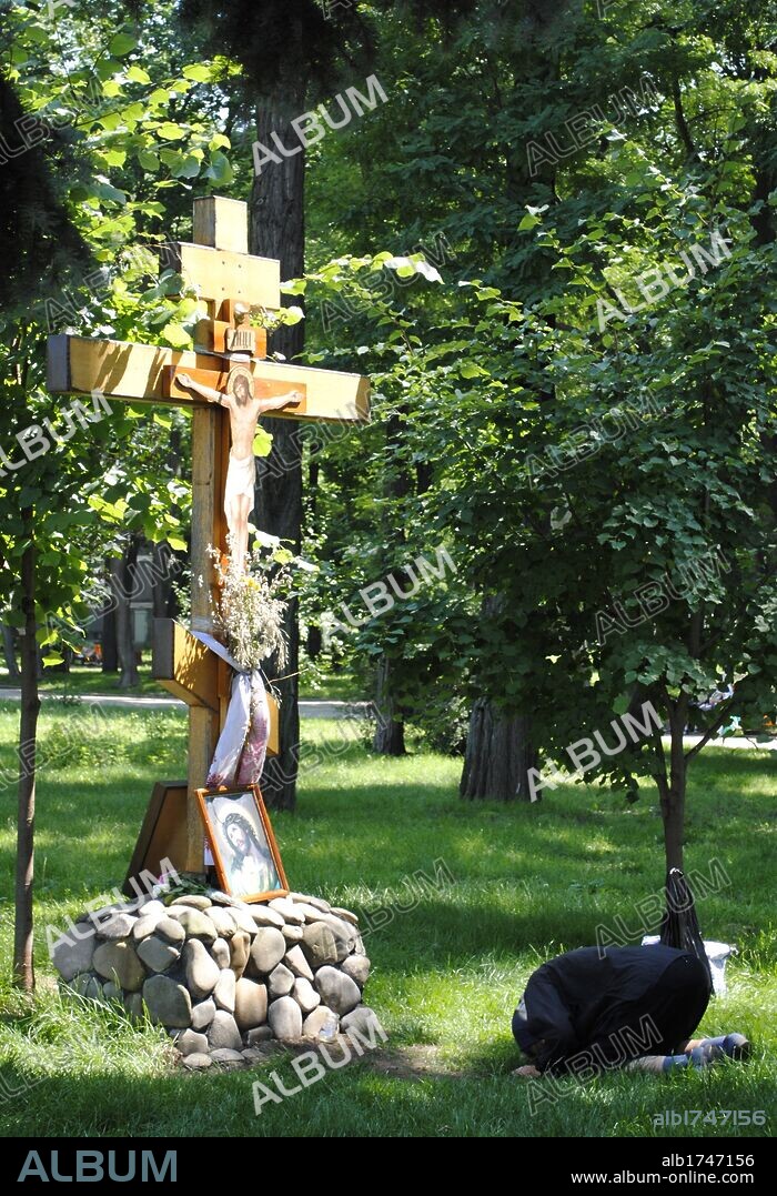 RELIGION CRISTIANA. IGLESIA ORTODOXA. Mujer ucraniana rezando ante una cruz. Parque Khreschatyk. Ciudad de Kiev. Ucrania. Europa oriental.