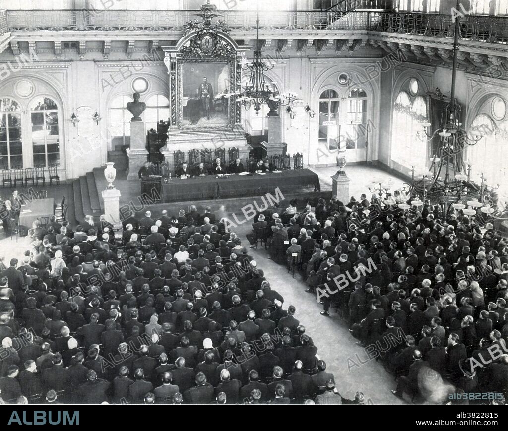 Captioned: "Meeting of the Union of the 17th October Members in th states Duma, 1913." The Union of October 17, commonly named Octobrist Party, was a non-revolutionary rightist Russian political party. The party's programme of moderate constitutionalism called for the fulfillment of Tsar Nicholas II's October Manifesto granted at the peak of the Russian Revolution of 1905. The Octobrists were firmly committed to a system of constitutional monarchy. At the same time they emphasized the need for a strong parliament and a government that would be responsible to it. The Octobrists and groups allied with them did poorly in the 1906 elections of the First and Second State Dumas. However, after the dissolution of the Second State Duma, the election law was changed in favor of propertied classes and the party formed the largest faction in the Third State Duma (1907-1912). The apparent failure of the party to take advantage of this majority and inability to influence the politics of the government led to a split within the party in 1913 and poor showing in the 1912 Duma election, resulting in a smaller faction in the Fourth State Duma (1912-1917). With the outbreak of WWI in August 1914, moderate political parties became moribund in Russia. The Octobrists all but ceased to exist outside the capital, St. Petersburg, by 1915. No photographer credited, dated 1913.