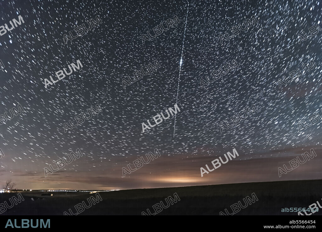 October 8, 2017 - A magnitude -4 Iridium satellite flare descending toward the northern horizon, shot in southern Alberta, Canada. There are numerous other satellite trails in the frame and at least one aircraft. While predicted to be -7, this flare was more like -4 at best. But the satellite was visible before and after the flare. This was Iridium #13.. The glow in the clouds is from Drumheller to the north.