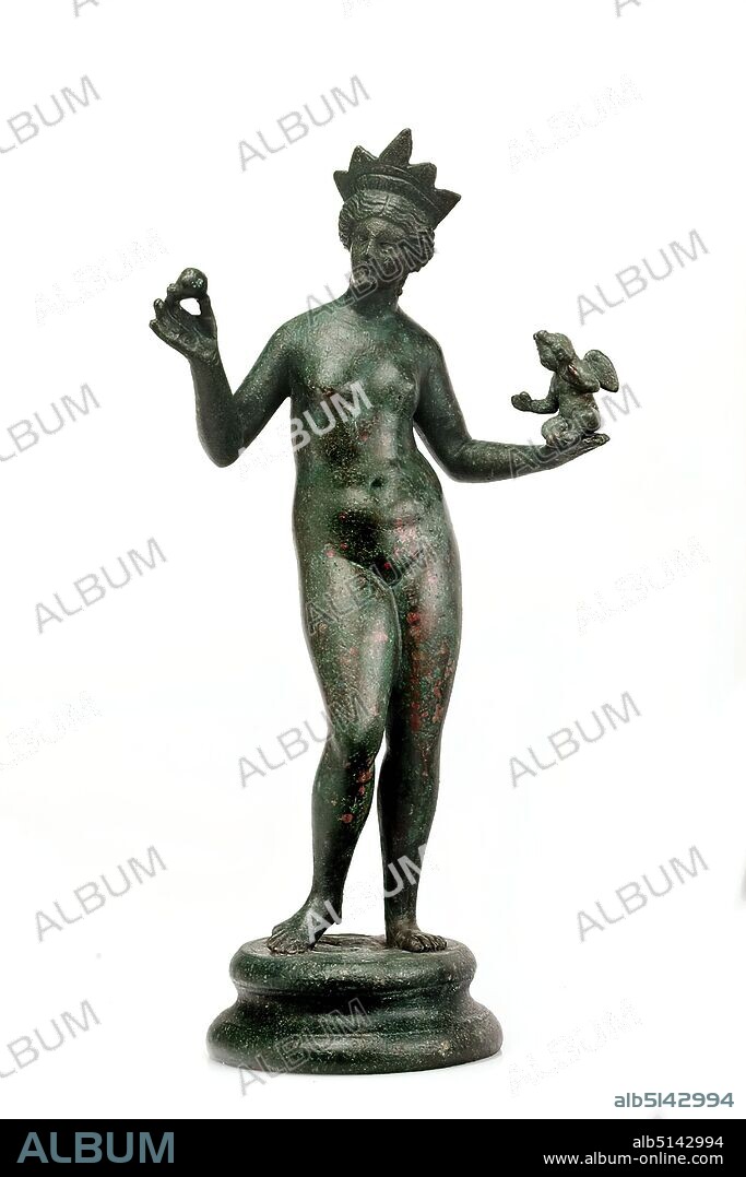 Praxiteles, Venus with Cupid, Bronze, cast, bronze, Total: Height: 24.00 cm; Width: 12.50 cm; Depth: 7.20 cm; Diameter: 7.50 cm (base), Small sculptures/small works of art, Venus and Cupid, Olympic Gods, Middle Imperial Era, Venus is naked, has her right arm angled up and holds a pomegranate in her hand The left arm is slightly stretched out; a small cupid is sitting on the palm of the hand. In her hair Venus wears a ray diadem. The statuette of Aphrodite is based on the statue of Aphrodite Anadyomene of the Praxiteles.