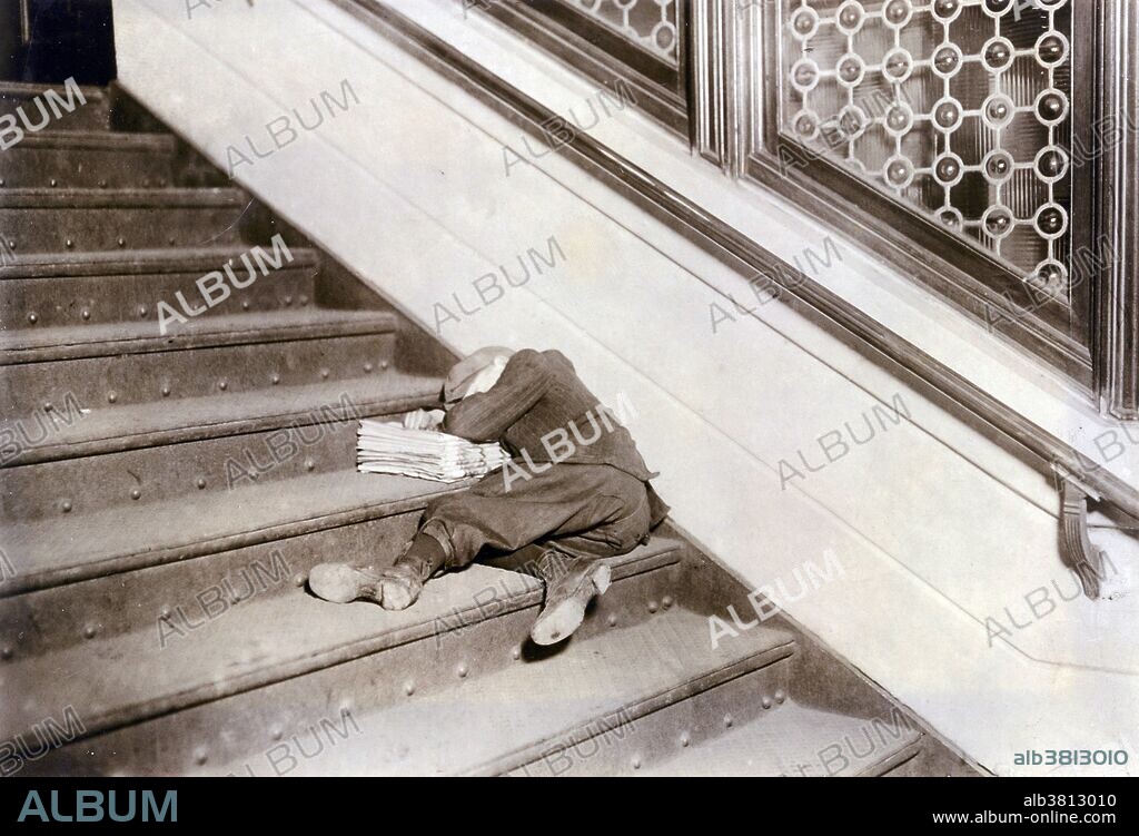 Entitled: "Newsboy asleep on stairs with papers, Jersey City, New Jersey" photographed by Lewis Hine, February 1912. In 1908, Hine accepted a position as chief investigator and photographer for the National Child Labor Committee (NCLC), a private organization founded in 1904 whose mission was to promote legislation to protect children from exploitation by American industry. At the time, children as young as four years old labored in a variety of trades eight to twelve hours a day in factories, tenements, and on the streets. Newspaper sellers, or newsies, fit into the category of street trades, a subject that engendered some of Hine's most lyrical photographs. Although Hine usually recorded the child's age, name, and work habits, he did not disturb this young boy, clearly exhausted from a long day's work. Instead, he captioned the photograph, made in New York City: "A sleeping newsboy found after midnight in the vestibule of a railroad station, newspapers for a pillow." But in fact the picture needs no caption, for the meaning of the scene is clearly stated, the child's hidden face and flattened body a metaphor for all that Hine and the NCLC tried to abolish. Asleep on his unsold goods, the boy is old news, left at the station and forgotten after the departure of the last train.