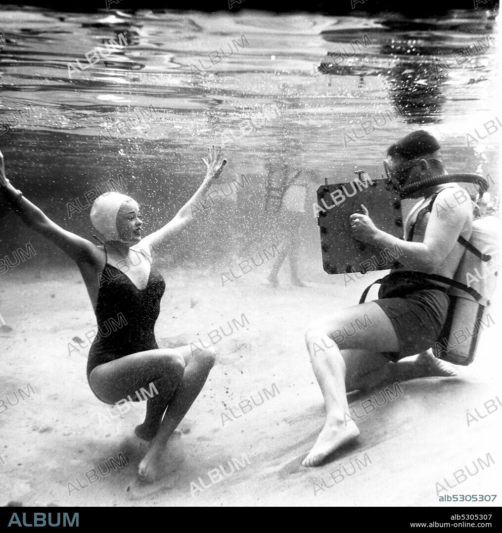 Circa 1955, Hollywood, California, USA: American actress and Hollywood sex symbol JAYNE MANSFIELD wearing a bathing suit, taking a dive in a swimming pool during an underwater publicity Junket for the Howard Hughes 1955 hit movie 'Underwater!'. In January 1955, Mansfield scored a plus-one to a press junket for Howard Hughes' Underwater starring Jane Russell. Outfitted in a skintight red lamŽ swimsuit, Mansfield dove into a pool and, according to journalists, ''had the genius to permit her bathing suit to split open.'' Overnight, Mansfield's image was plastered across America.