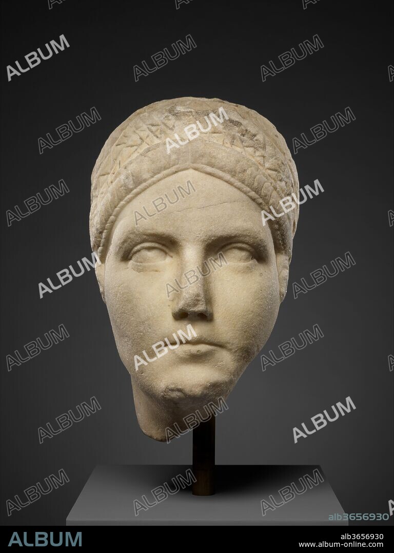 Marble portrait, probably of Matidia, niece of the emperor Trajan and mother of Sabina, wife of the emperor Hadrian. Culture: Roman. Dimensions: H. 11 1/4 in. (28.6 cm). Date: A.D. 117-138.
This portrait resembles those of Matidia, daughter of Marciana, elder sister of the emperor Trajan. Strands appear to be woven in a braid-like pattern through the double crescents that form the artificial hairpiece surrounding the face, but the structure is lower than on many of the official images of Matidia.