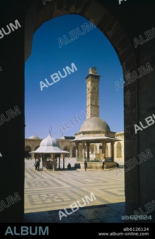 Aleppo (Syria), Great Mosque / Umayyad Mosque / Jami' Halab al-Kabir (founded c.710; restored and extended after a fire in 1169 under sultan Nur al-Din; minaret built 1090-95 under Abu'l Hasan Muhammad, modified 14th/15th century, destroyed during the civil war in 2013). View across the courtyard with fountain and minaret. Photo, undated.