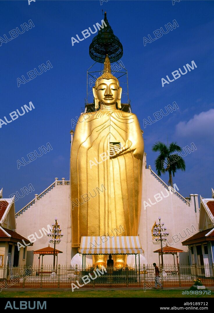 Thailand: Giant standing Buddha, Wat Intharawihan, Bangkok. The main feature of Bangkok's Wat Intharawihan is the 32-metre high standing Buddha called either Luang Pho To or Phrasiariyametri. It took over 60 years to complete and is decorated in glass mosaics and 24-carat gold. The topknot of the Buddha image contains a relic of Lord Buddha brought from Sri Lanka. The temple was built at the beginning of the Ayutthaya period.