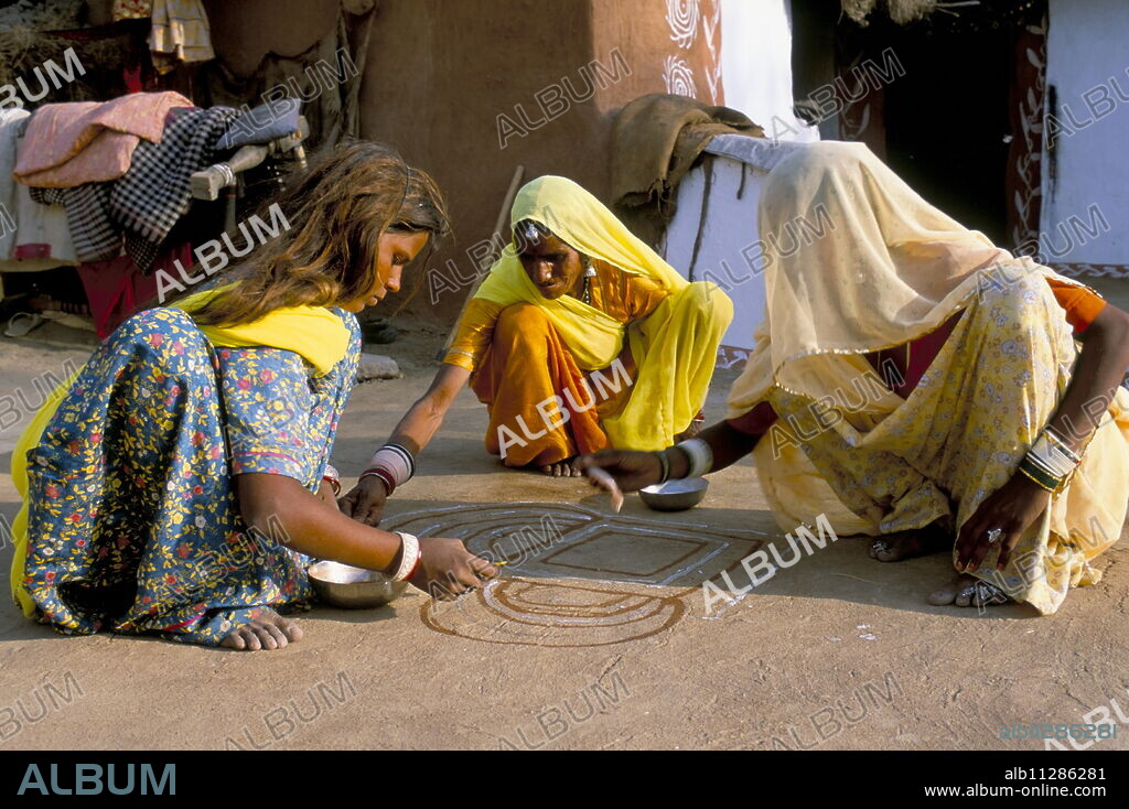 Women painting a mandana on the ground, village near Jodhpur, Rajasthan state, India, Asia.