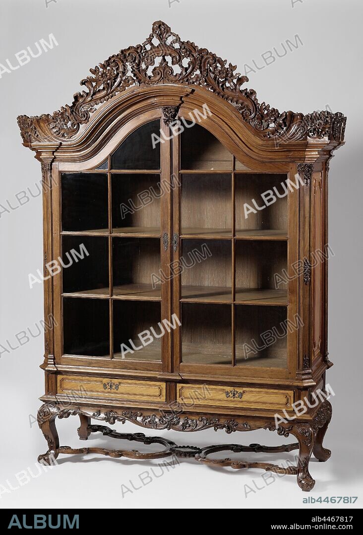 Paddle cupboard and ironwood cupboard, Paddle cupboard and ironwood cupboard. The cabinet rests on a low base with S-shaped curved legs, connected by a slung cross. the entire frame is decorated with carved tendrils. The cupboard, which has a curved hood, has two doors with a rod partition with glass windows above two drawers. The corner posts placed at an angle are treated as pilasters and the middle post also has a capital-like ornament. The entire canopy is crowned by open-cut carving of flower and leaf vines. Louis XVI lock plates and tractors made of silver., anonymous, Indonesia, 1740 - 1760, padouk (wood), ironwood, silver (metal), h 280 cm × w 200 cm × d 84 cm.
