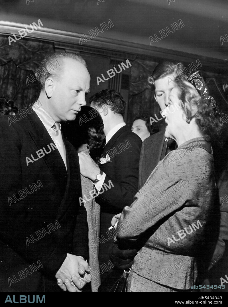 Mr. Godfrey Winn, the journalist and writer, talking to Dorothy Dixon the actress. Miss Dixon is mother-in-law to Anthony Quayle; her daughter, Dorothy Hyson, gave up her stage career shortly after her marriage to Mr. Quayle. June 1, 1953. (Photo by Camera Press Ltd.).
