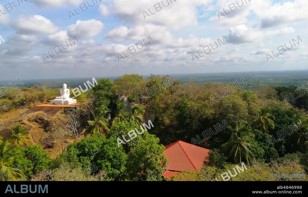 Rock-carved steps leading to a large white Buddha statue. Mihintale is a mountain peak near Anuradhapura in Sri Lanka. It is believed by Sri Lankans to be the site of a meeting between the Buddhist monk Mahinda and King Devanampiyatissa which inaugurated the presence of Buddhism in Sri Lanka.