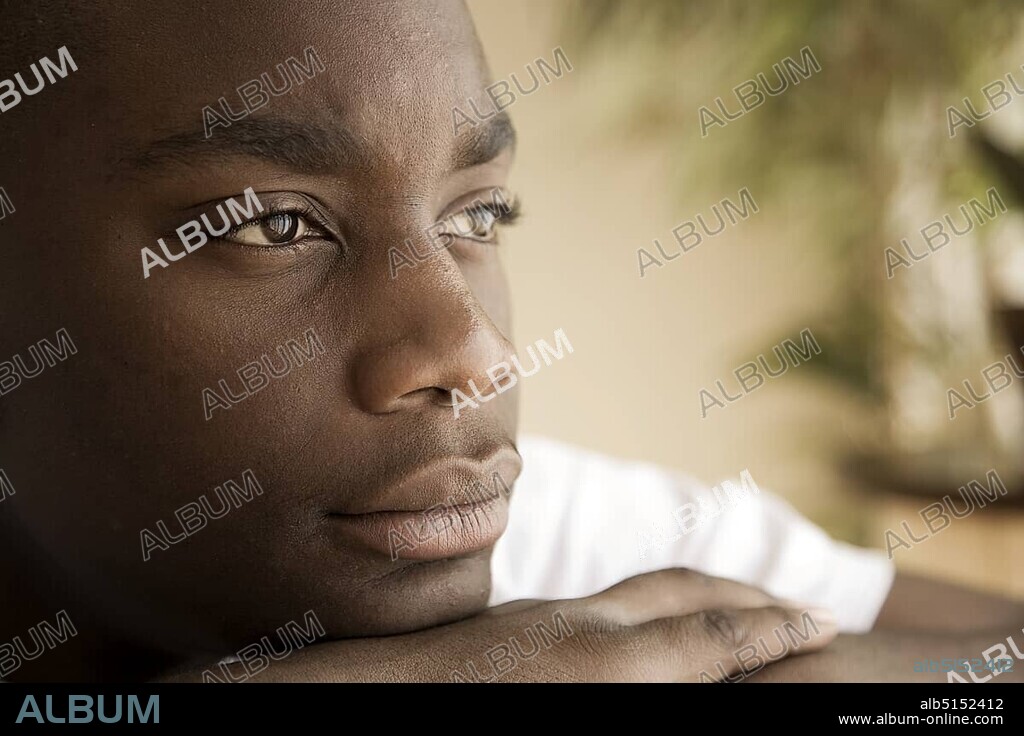 Dark-skinned, 15-year-old boy, faraway look in eyes.