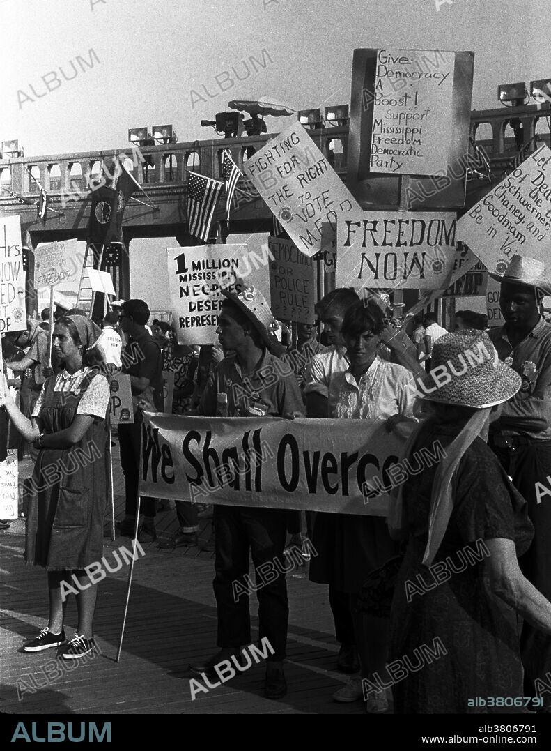 Entitled: "African-American and white supporters of the Mississippi Freedom Democratic Party holding signs in front of the convention hall at the 1964 Democratic National Convention, Atlantic City, New Jersey." The Mississippi Freedom Democratic Party (MFDP) was an American political party created in the state of Mississippi in 1964, during the civil rights movement. It was organized by African Americans from Mississippi, with assistance from the Student Nonviolent Coordinating Committee (SNCC) and Council of Federated Organizations (COFO), to challenge the legitimacy of the then-white-only Mississippi Democratic Party. The MFDP sent its elected delegates by bus to the Democratic National Convention in New Jersey. There they challenged the right of the Mississippi Democratic Party's delegation to participate in the convention, claiming that the regulars had been illegally elected in a completely segregated process that violated both party regulations and federal law, and that furthermore the regulars had no intention of supporting Lyndon B. Johnson, the party's presidential candidate, in the November election. They therefore asked that the MFDP delegates be seated rather than the segregationist regulars. Even though they were denied official recognition, the MFDP kept up their agitation within the Convention. Photographed by Warren K. Leffler, August, 1964.