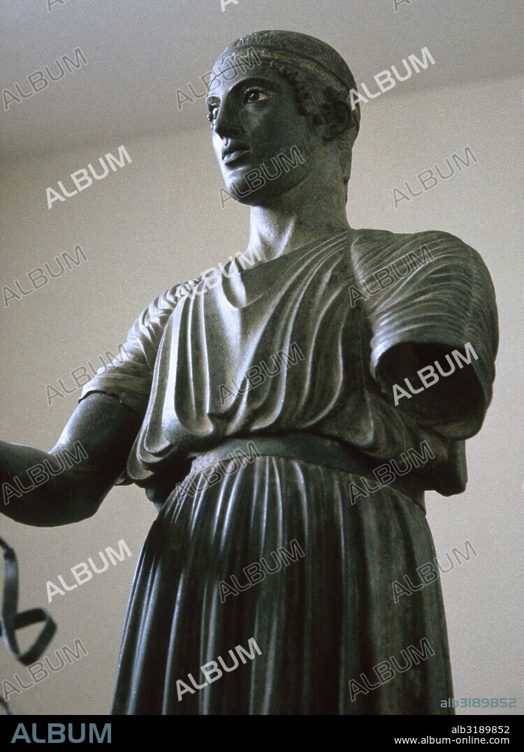 ARTE GRIEGO. "AURIGA". Estatua de bronce ofrecida a Apolo por Polyzalos, tirano de Gela (Sicilia), para conseguir la victoria en una carrera de cuádrigas en los juegos Píticos del año 478 ó 474 a. C. El Auriga lleva la larga túnica de los conductores de cuádrigas llamados Xystis. Detalle. Museo de Delfos. Grecia.