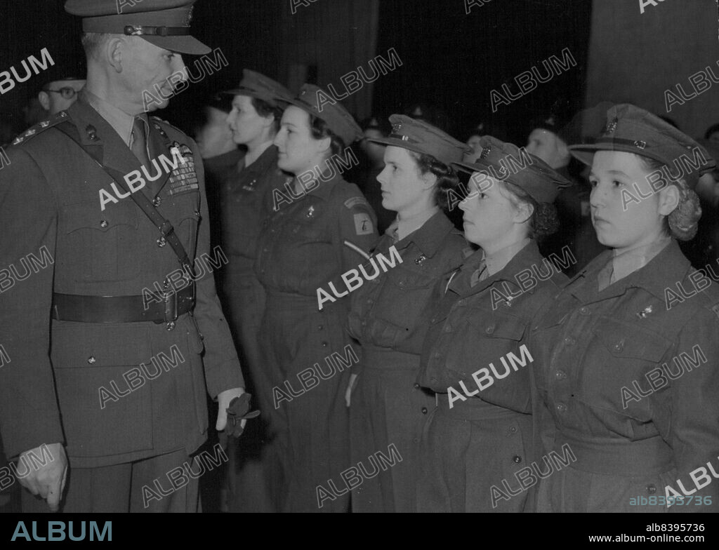 Back To The Old Uniform -- Wearing Khaki Service dress, Marshal of the Royal Air Force Lord Tedder - Chief of the Air Staff inspects women members of the 190 (Mixed) Heavy Anti-Aircraft Regiment (Territorial Army) at the Finchley (North London) drill hall when he became honorary colonel of the unit. This is not Lord Tedder's first appearance in Army uniform - he was commissioned in the Dorsetshiare Regiment in 1914 before he was seconded to the Royal Flying Corps. He is believed to be the first airman to become honorary colonel of a British Army unit. February 22, 1949.