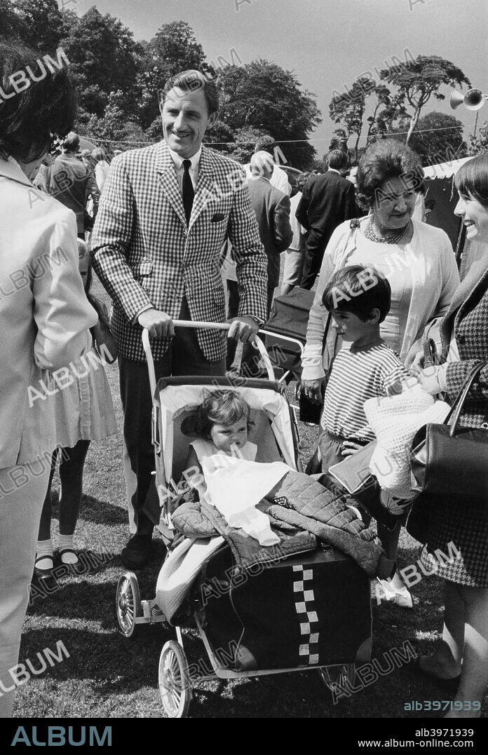 Graham Hill with his family, c1968. Damon Hill is the boy in the striped T-shirt next to the push-chair. Graham Hill made his debut at Monaco in 1958 and went on to win 14 Grands Prix. He also won the Formula One world driver's championship in 1962 and in 1968. He was killed in a plane crash in 1975 with five other members of his Embassy Hill team. Damon followed his father into motor racing, winning 22 Formula 1 Grands Prix, and emulating him by winning the World Drivers' Championship in 1996.